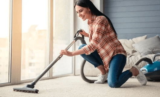 Lady vacuuming carpet floor | Affordable Floors